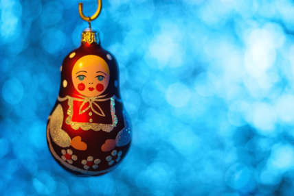 Close up of Christmas ball Matryoshka over blurred shiny background. Selective focus.