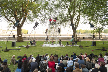 Performers on sway poles around metal structure