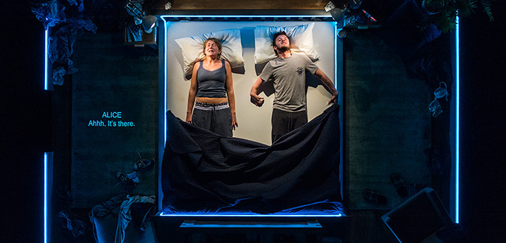 Image of Alice and Phil in bed on the set 'The Solid Life of Sugar Water