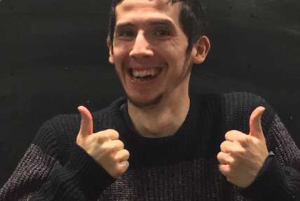 Headshot of Josh smiling with his thumbs up