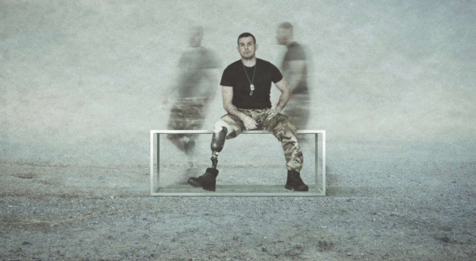 A man sits on a bench, whilst the blurry afterimages of other men flit behind him