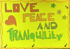 This image by Colette Creswell is on bright yellow paper. Across the paper are written “love peace and tranquilly” each word is in a different font and the words are written in red orange, black and green. There is a border around the image made up of orange semi circles. There are also music notes, stars and a large red heart in the image. The artist made this image because they need to remind themselves that in their life, they need love peace and tranquilly and also thought that this was a message that should go out to everyone.